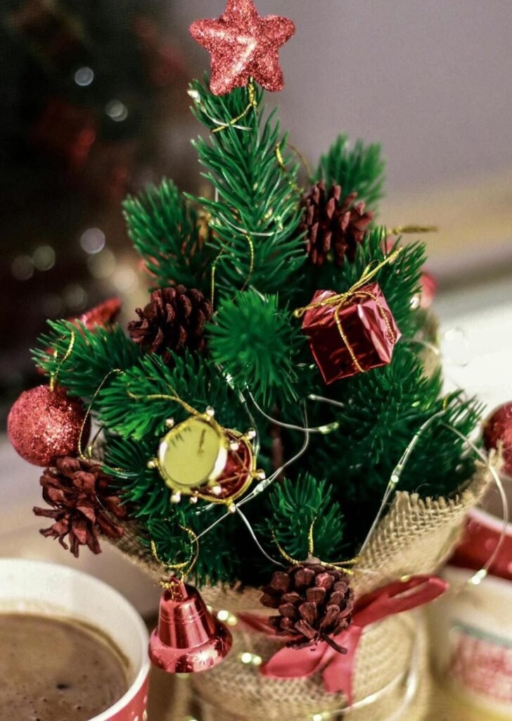 árvore de Natal pequena com enfeites coloridos em um ambiente interno acolhedor.