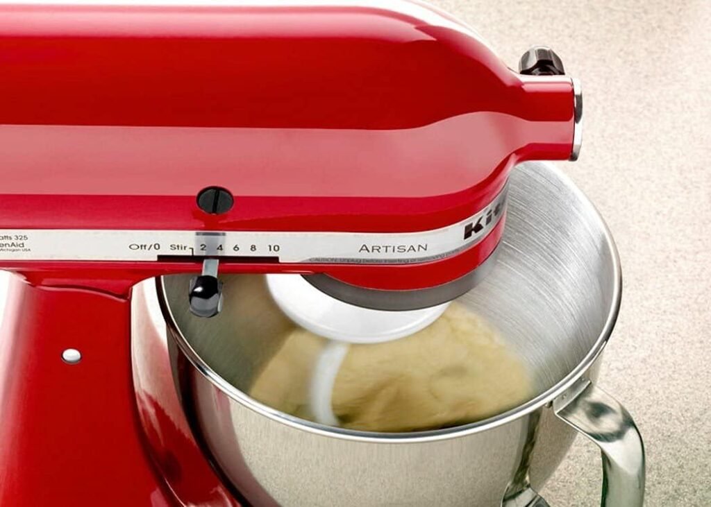 batedeira kitchenaid artisan vermelha batendo massa sobre bancada